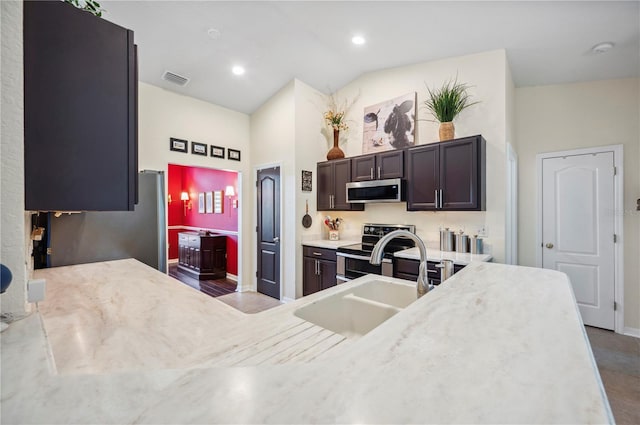 kitchen with dark brown cabinetry, stainless steel appliances, sink, and high vaulted ceiling