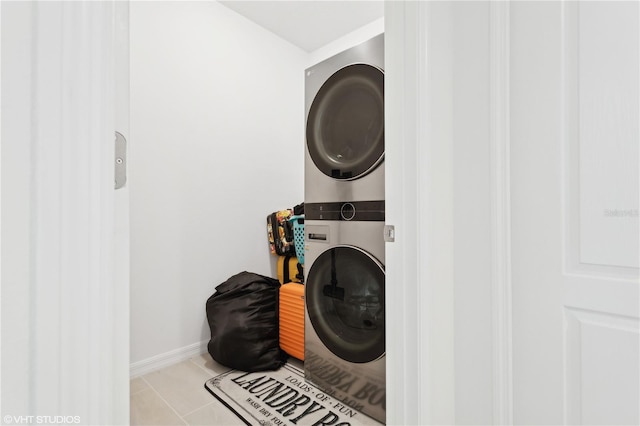 clothes washing area featuring stacked washer and dryer and light tile patterned floors