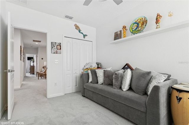 carpeted living room with ceiling fan