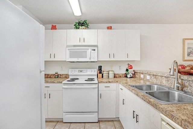 kitchen with sink, a textured ceiling, light tile patterned floors, white appliances, and white cabinets