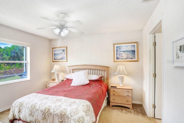 carpeted bedroom with a textured ceiling and ceiling fan