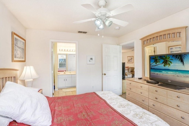 bedroom with ceiling fan, ensuite bath, and sink