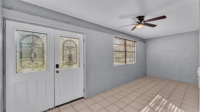 tiled foyer entrance with french doors and ceiling fan