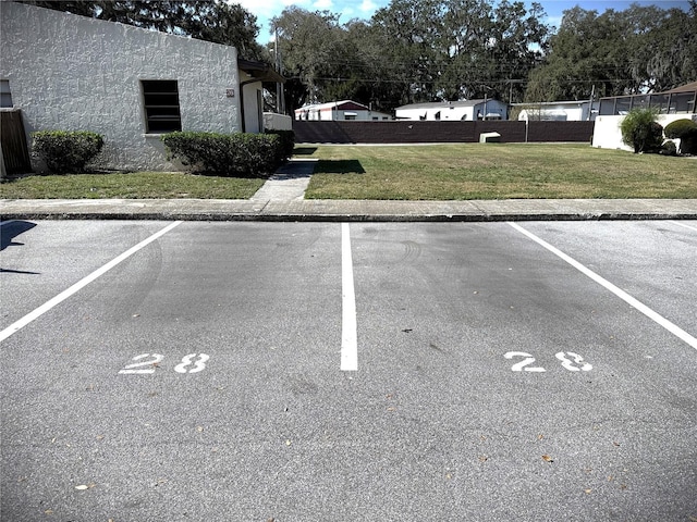 view of parking with a lawn