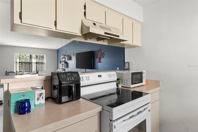 kitchen with white electric stove, kitchen peninsula, a textured ceiling, and cream cabinetry