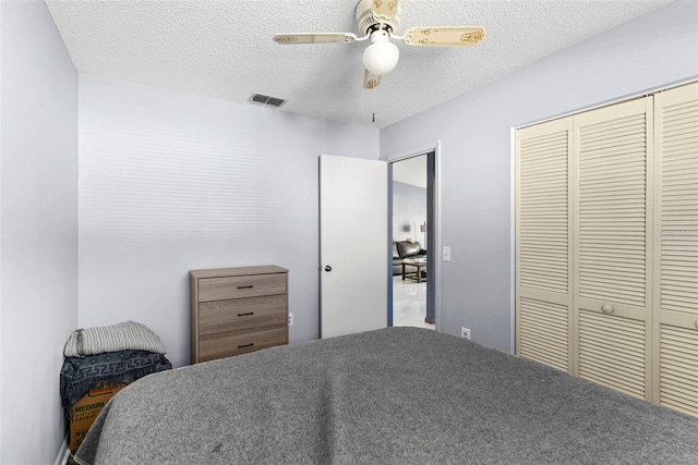 bedroom with ceiling fan, a closet, and a textured ceiling