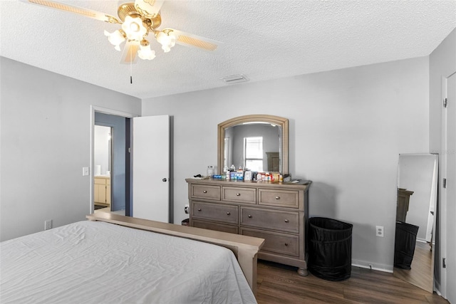 bedroom with ceiling fan, dark hardwood / wood-style floors, and a textured ceiling