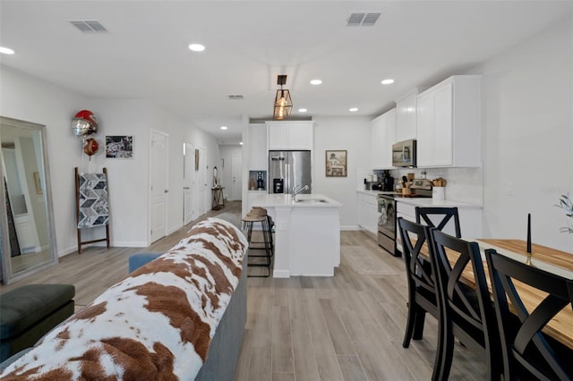 living room with sink and light hardwood / wood-style flooring