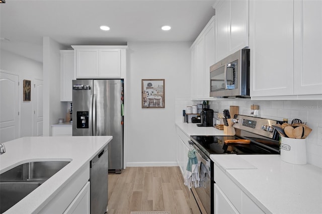 kitchen with appliances with stainless steel finishes, sink, and white cabinets