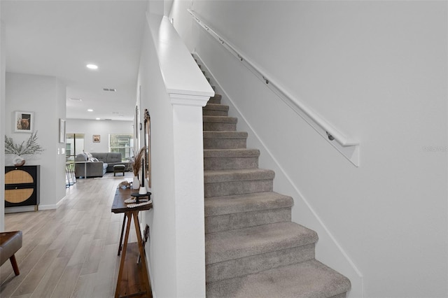 stairs featuring hardwood / wood-style floors