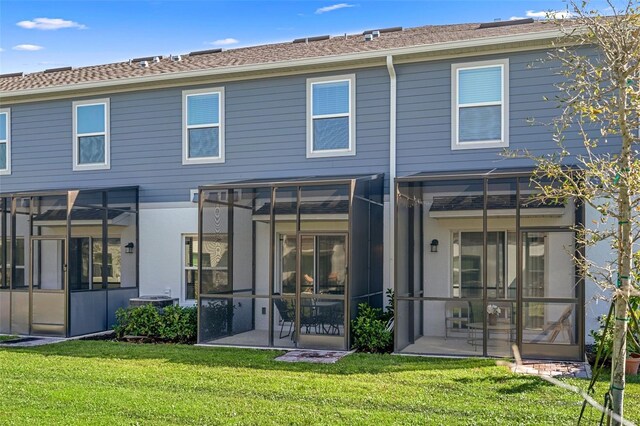 rear view of property featuring a patio and a lawn