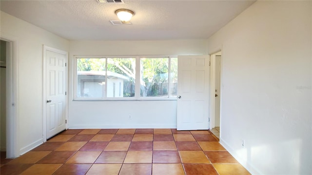 interior space with tile patterned floors and a textured ceiling