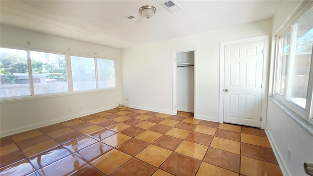 unfurnished bedroom featuring light tile patterned floors and a closet