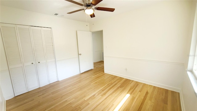 unfurnished bedroom with light hardwood / wood-style flooring, a closet, and ceiling fan