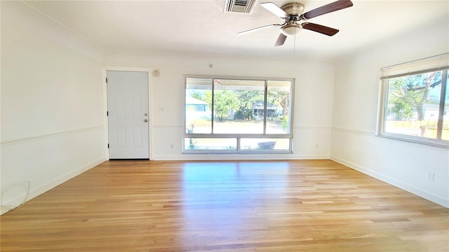 spare room featuring a wealth of natural light, ceiling fan, and light wood-type flooring