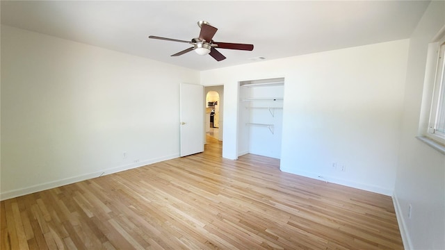 unfurnished bedroom with ceiling fan, a closet, and light wood-type flooring