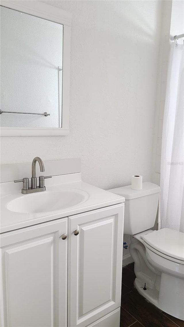 bathroom with vanity, toilet, and walk in shower