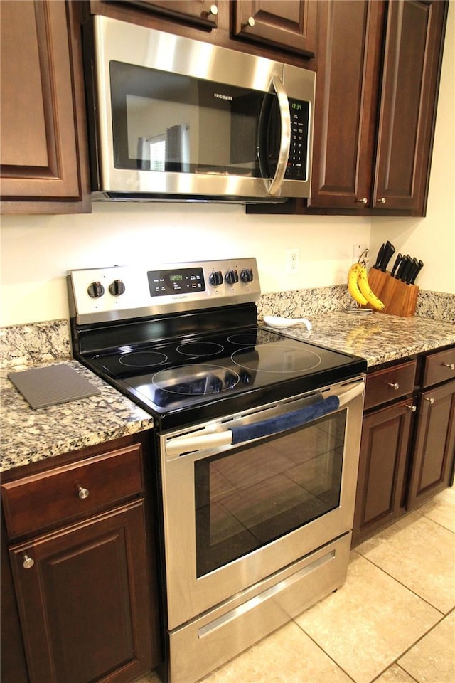 kitchen featuring light stone countertops, appliances with stainless steel finishes, and dark brown cabinetry