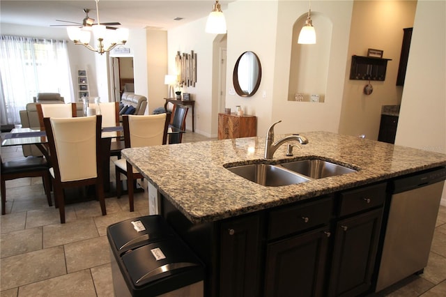 kitchen with stainless steel dishwasher, an island with sink, sink, and hanging light fixtures