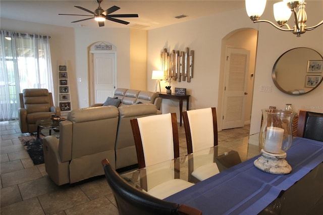 dining room with ceiling fan with notable chandelier