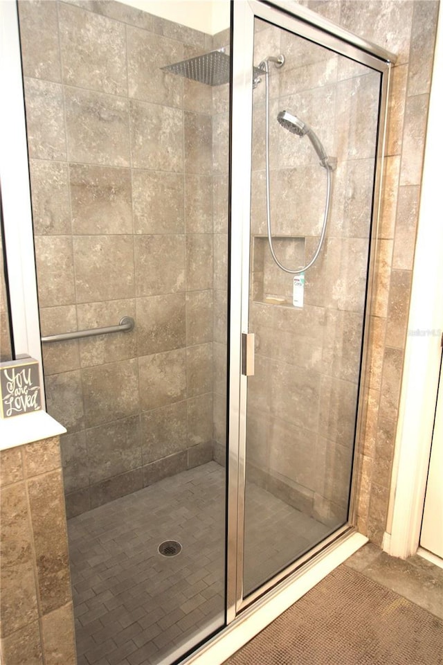 bathroom with an enclosed shower and tile patterned floors