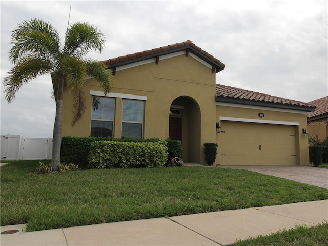 mediterranean / spanish house featuring a garage and a front yard