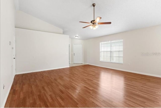 spare room with vaulted ceiling, hardwood / wood-style floors, and ceiling fan