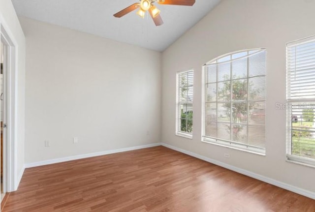 unfurnished room with hardwood / wood-style flooring, vaulted ceiling, and ceiling fan