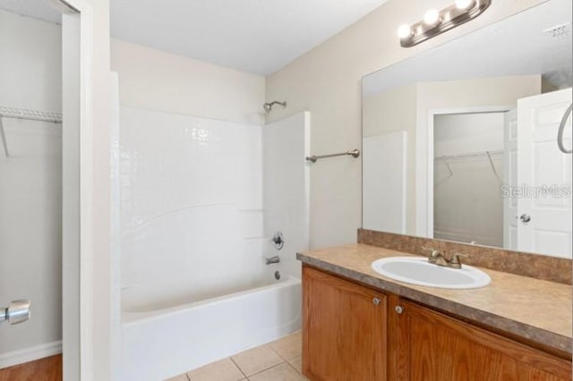 bathroom featuring tile patterned flooring, shower / washtub combination, and vanity