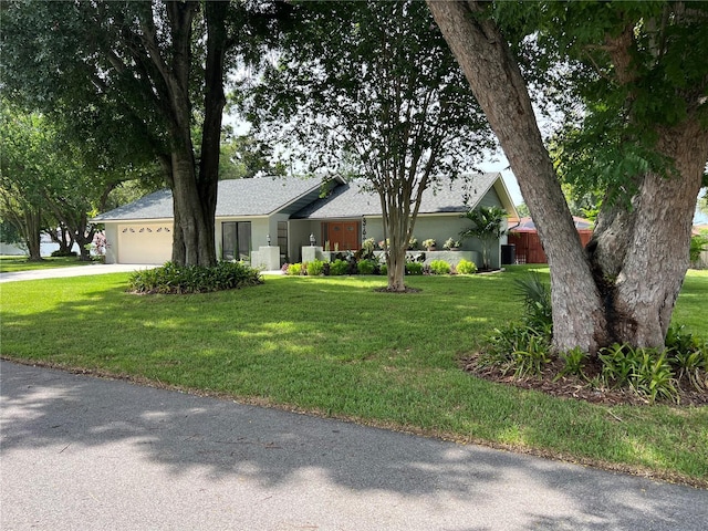 single story home featuring a garage and a front lawn