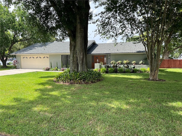 ranch-style house featuring a garage and a front lawn