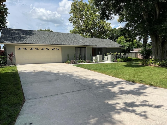 single story home with a garage and a front lawn