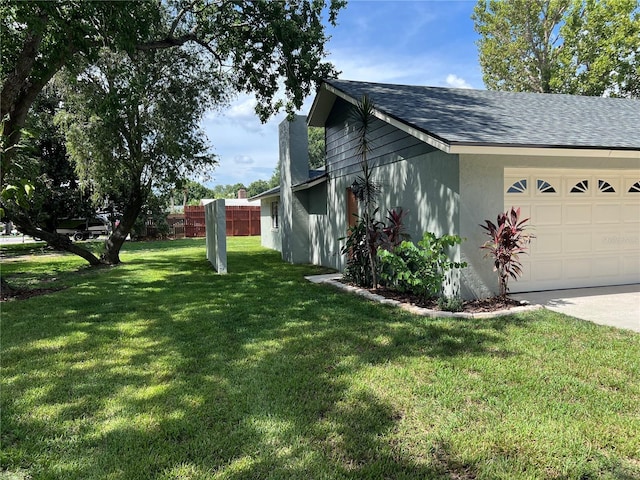 view of side of property featuring a garage and a yard