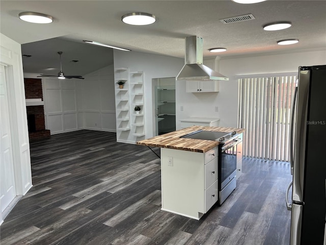 kitchen with dark wood-type flooring, butcher block counters, stainless steel appliances, island range hood, and white cabinets