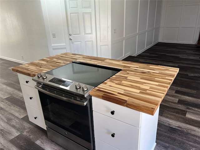 kitchen featuring stainless steel range with electric stovetop, dark wood-type flooring, wooden counters, and white cabinets