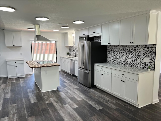 kitchen featuring a kitchen island, white cabinetry, sink, stainless steel appliances, and dark wood-type flooring