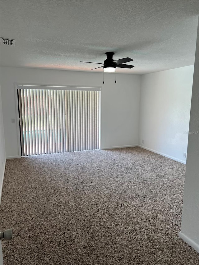 unfurnished room featuring a healthy amount of sunlight, carpet, and a textured ceiling