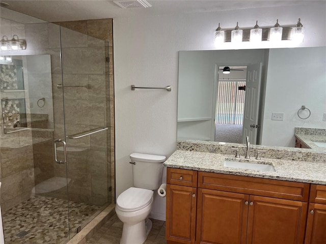 bathroom featuring vanity, toilet, an enclosed shower, and tile patterned flooring