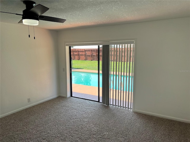 carpeted spare room with ceiling fan and a textured ceiling