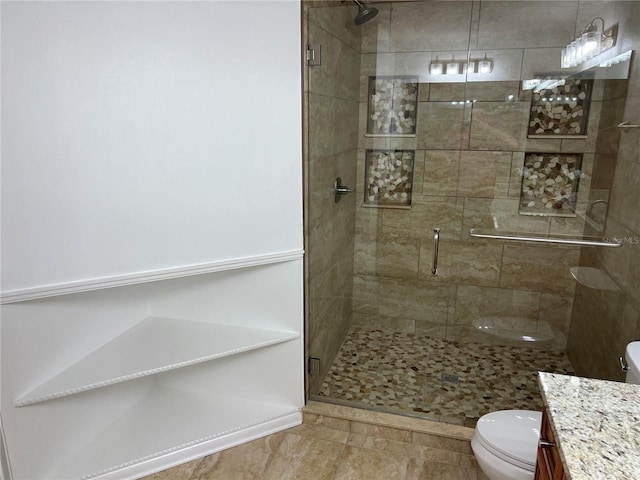 bathroom featuring vanity, an enclosed shower, and toilet