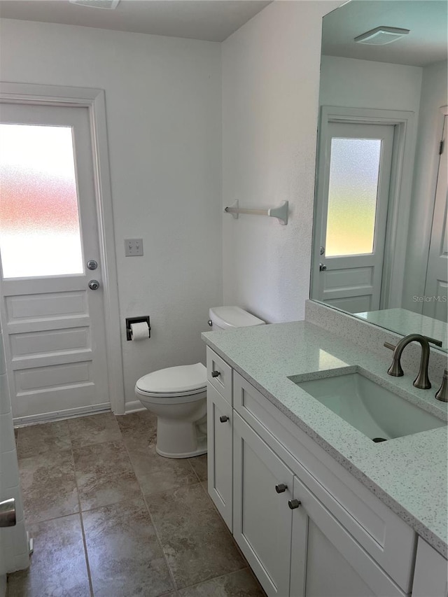 bathroom with vanity, plenty of natural light, and toilet