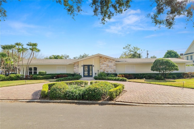 single story home with a front lawn and french doors