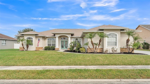 mediterranean / spanish-style home featuring french doors and a front yard