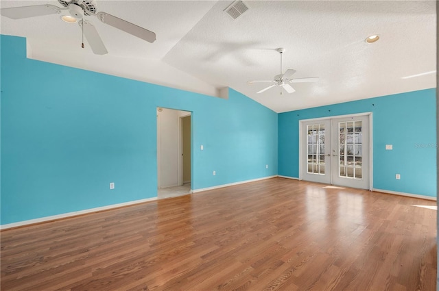 unfurnished living room with ceiling fan, wood-type flooring, a textured ceiling, vaulted ceiling, and french doors