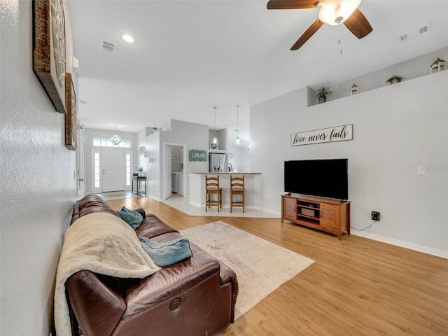 living room featuring light hardwood / wood-style floors and ceiling fan