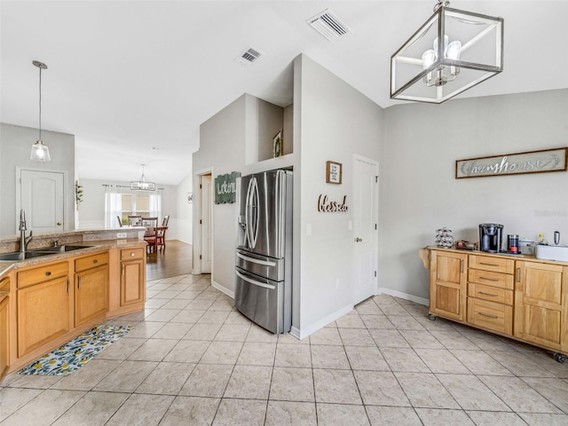 kitchen with sink, an inviting chandelier, stainless steel fridge with ice dispenser, hanging light fixtures, and light tile patterned floors