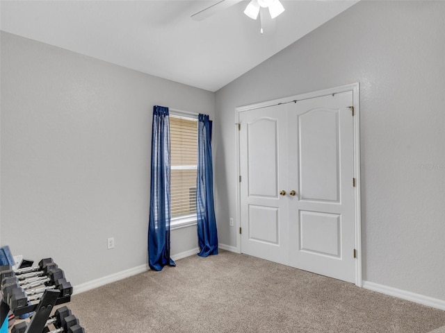 interior space featuring ceiling fan, carpet flooring, and vaulted ceiling