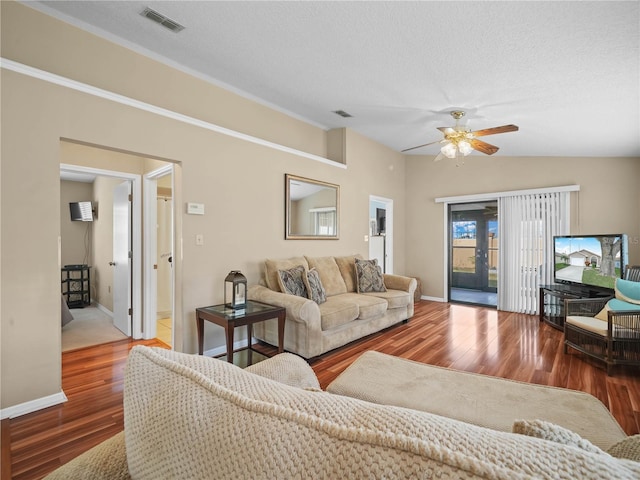 living room featuring wood-type flooring, vaulted ceiling, ceiling fan, and a textured ceiling