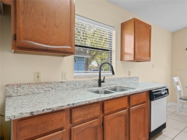 kitchen with sink, light tile patterned floors, light stone countertops, a textured ceiling, and stainless steel dishwasher