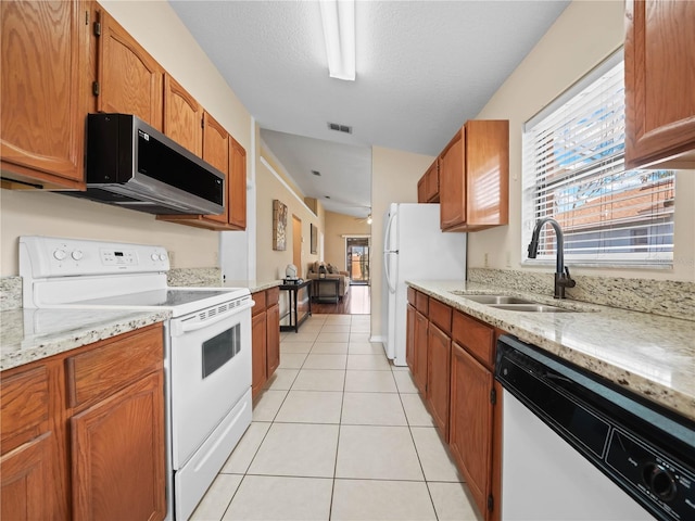 kitchen featuring sink, light tile patterned floors, plenty of natural light, and appliances with stainless steel finishes